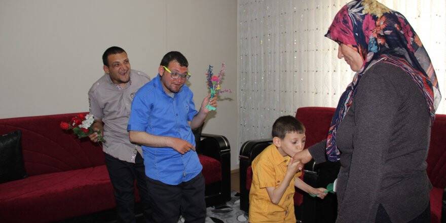 Engelli çocuklarına bebek şefkatiyle bakıyor