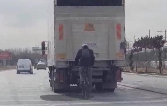 Bisikletle kamyon arkasındaki tehlikeli yolculuk hayrete düşürdü
