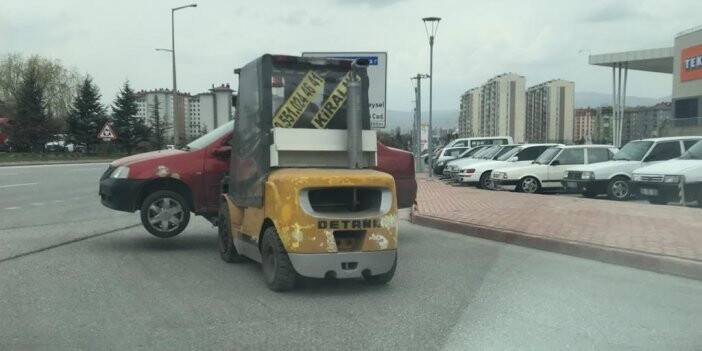 Forklift ile caddede otomobil taşıdı