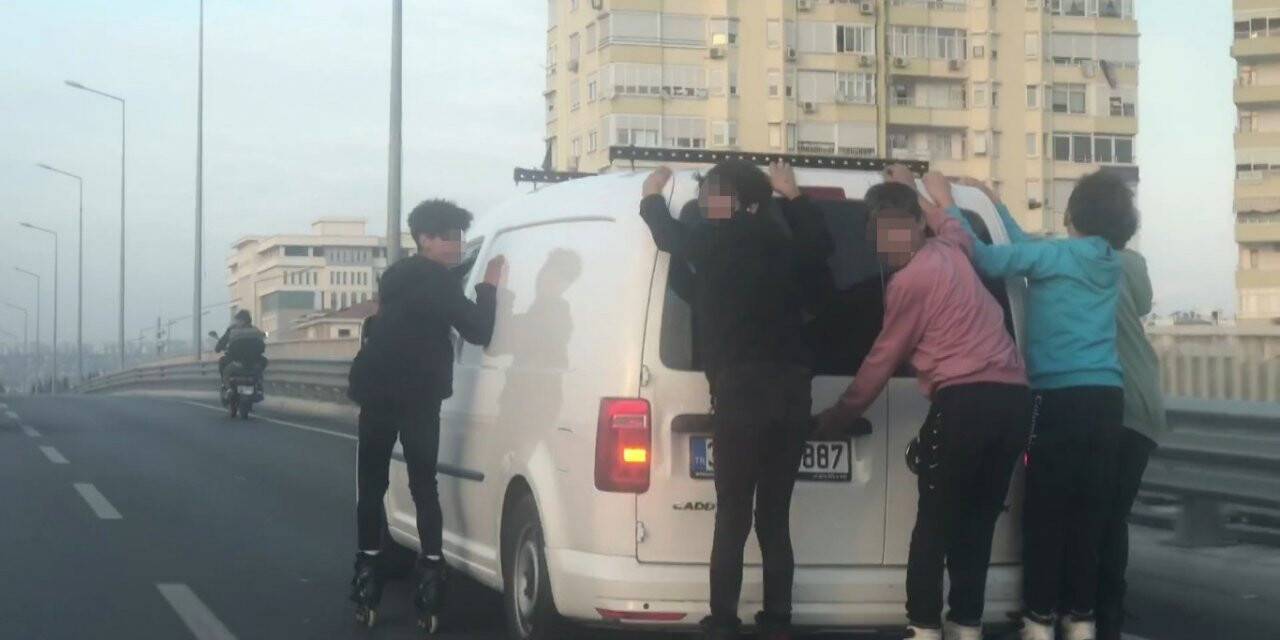 Ticari aracın arkasına yapışıp hız yapan patenciler polisi görünce çil yavrusu gibi dağıldı