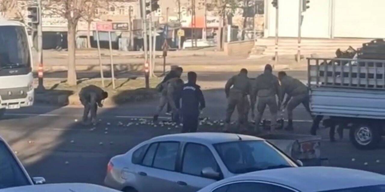 Yola saçılan elmaları, askerler elleriyle topladı