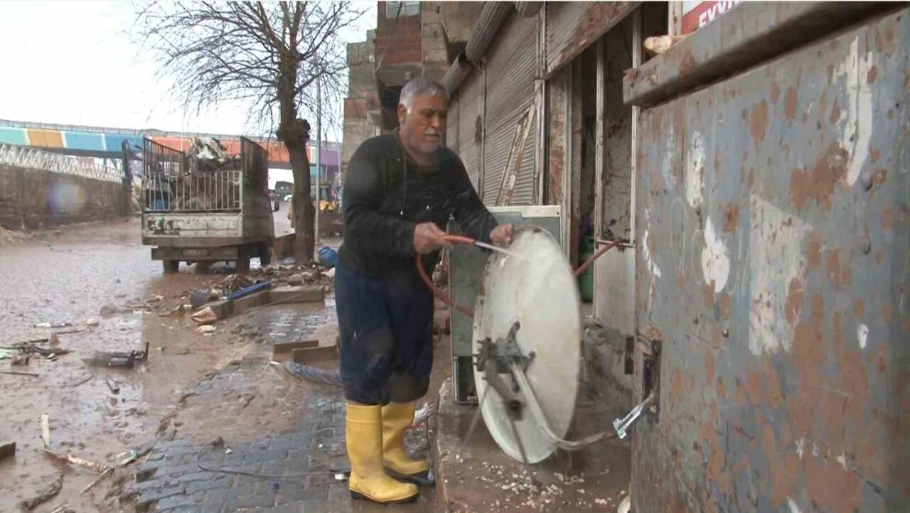 Şiddetli yağmur ve sele aldırış etmeden hortumla çanak anten yıkadı