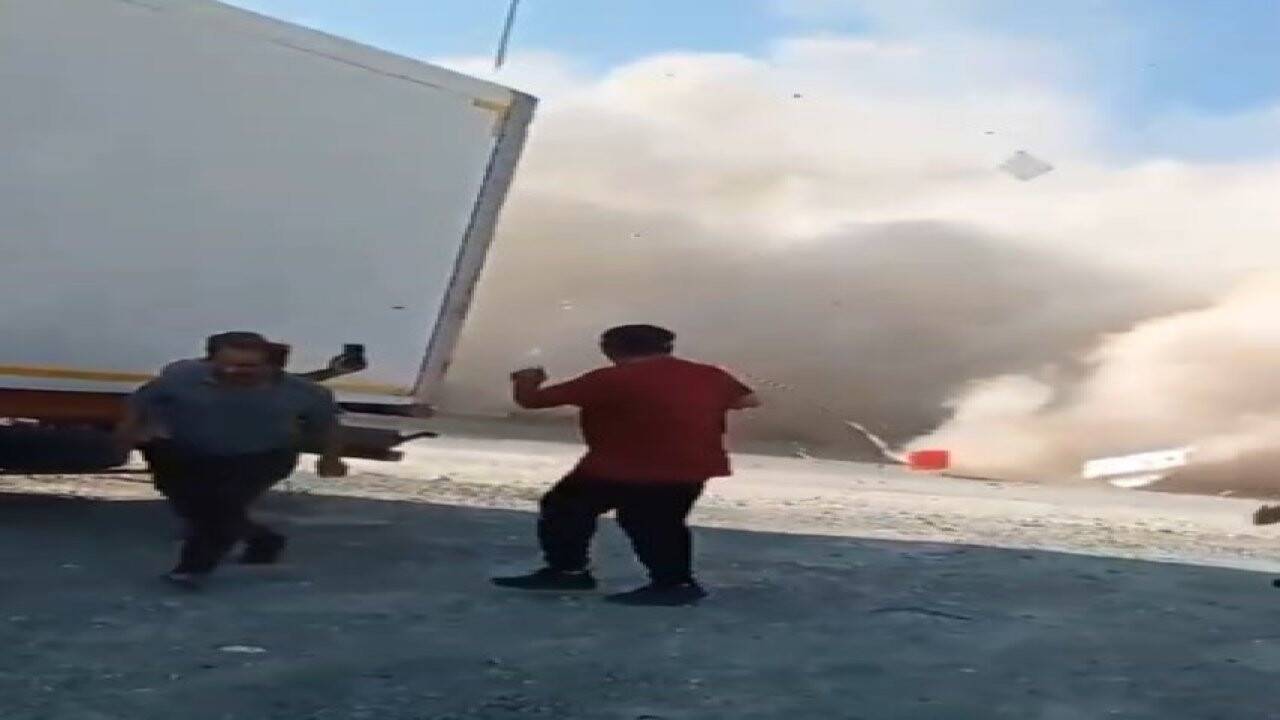 Depremde zarar gören binanın yıkımı sırasında molozlar yola devrildi