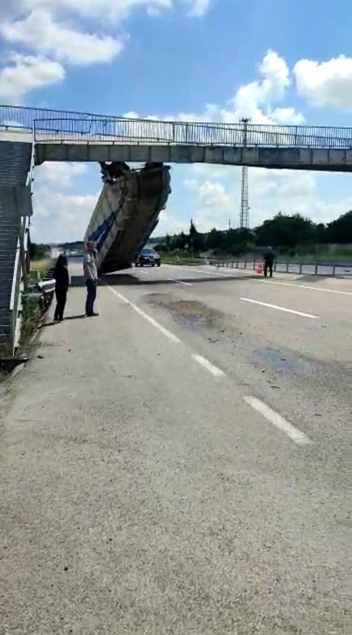 Tırın açık kalan dorsesi üst geçitte asılı kaldı