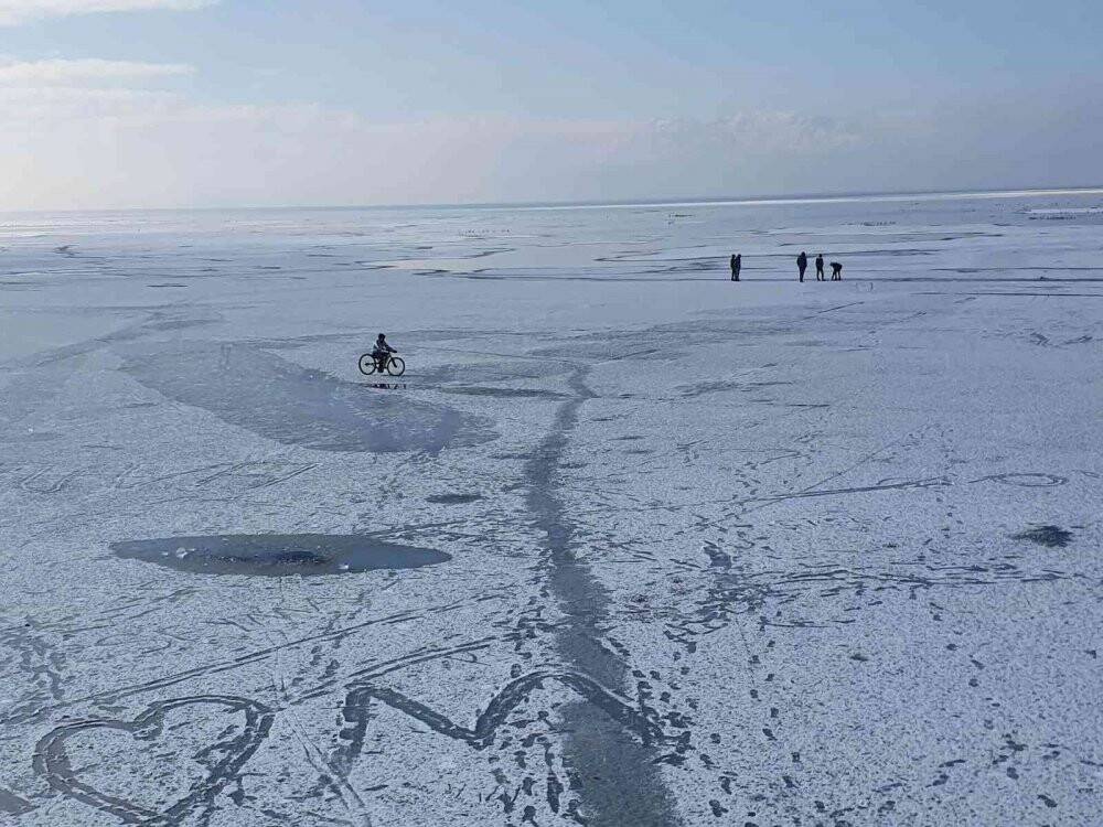 Buz tutan gölde tehlikeye rağmen yürüyüp bisiklet sürdüler