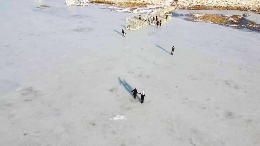 Buzları erimeye başlayan gölde tehlikeli yürüyüş