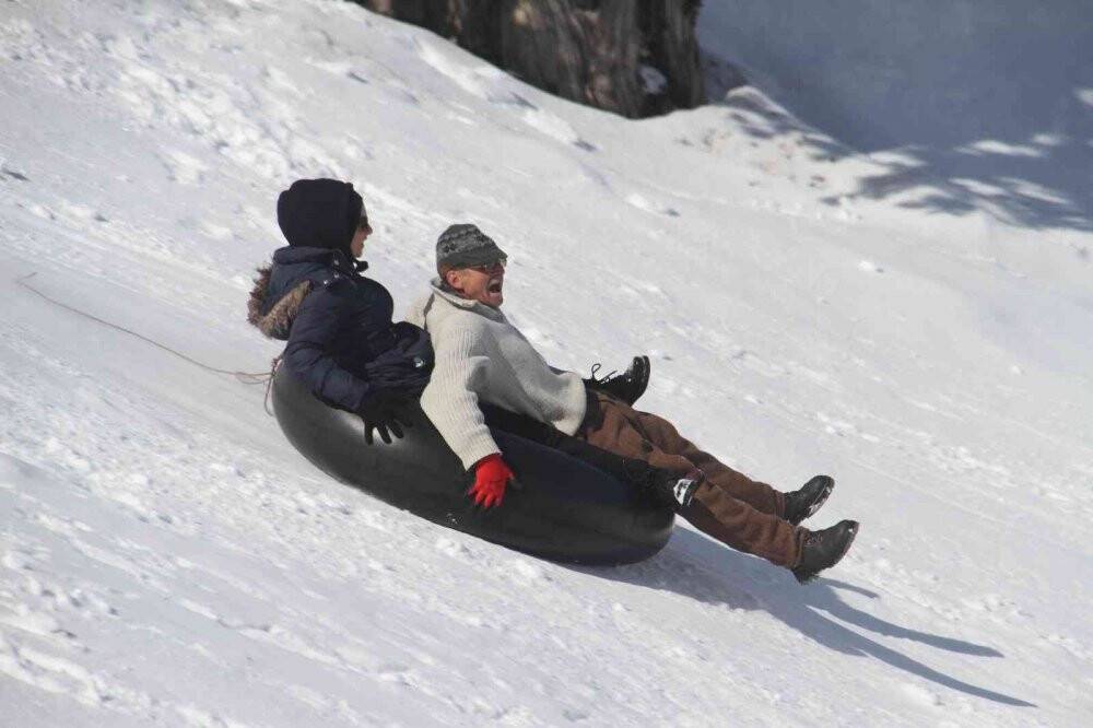 Konya’da piknikçi ailelerin karla kaplı dağlarda kayak keyfi