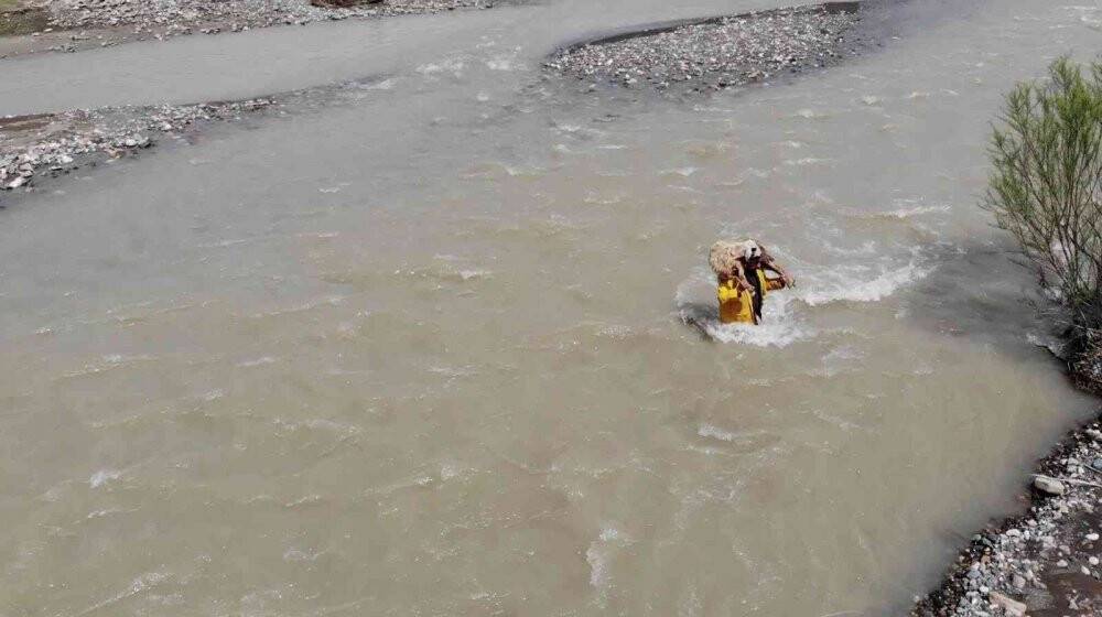 Sesini duyurabilmek için koyunu sırtında akarsudan geçirdi