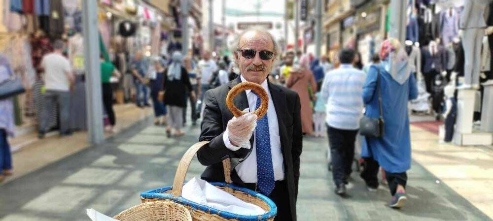 Sıcak havada her gün 20 kilometre yürüyerek takım elbiseyle simit satıyor