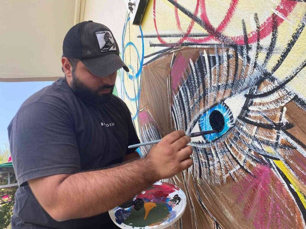 Doktor tavsiyesiyle ressam olan üniversiteli genç mahalleyi açık hava sergisine çevirdi