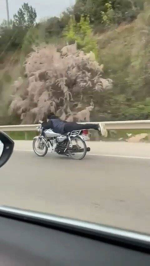 Canını hiçe saydı, motosikletin üzerinde uzanarak seyretti