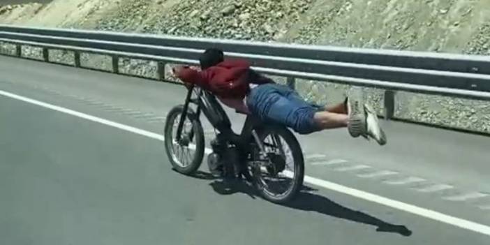 Motosikletin üstüne yatan sürücünün tehlikeli yolculuğu kamerada